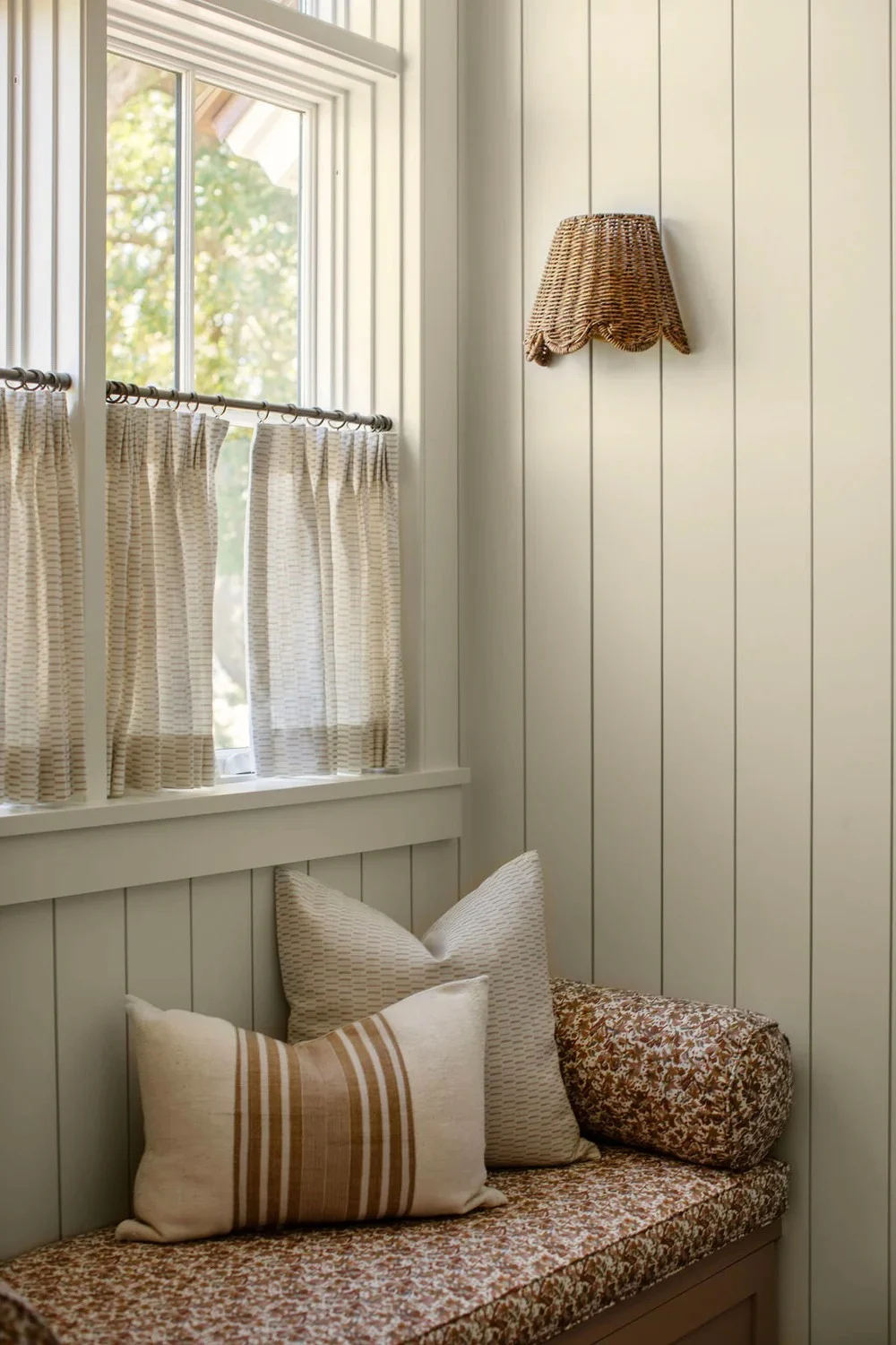 Emily Daws Sweetgrass fabric in Bloom café curtains above a built-in seat upholstered in Eden fabric in Autumn.