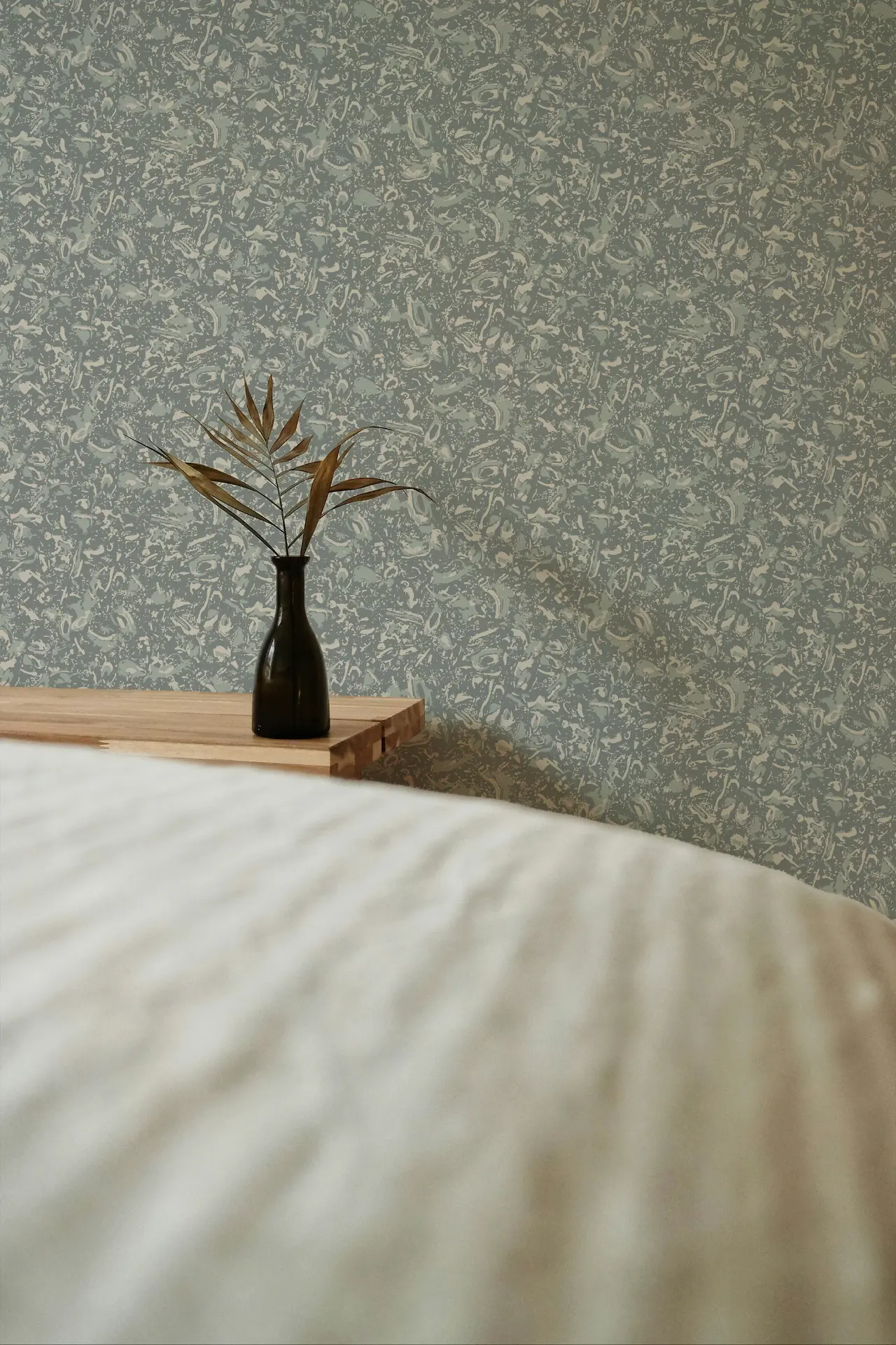 River Reef Grasscloth in Ocean shown in a bedroom detail.
